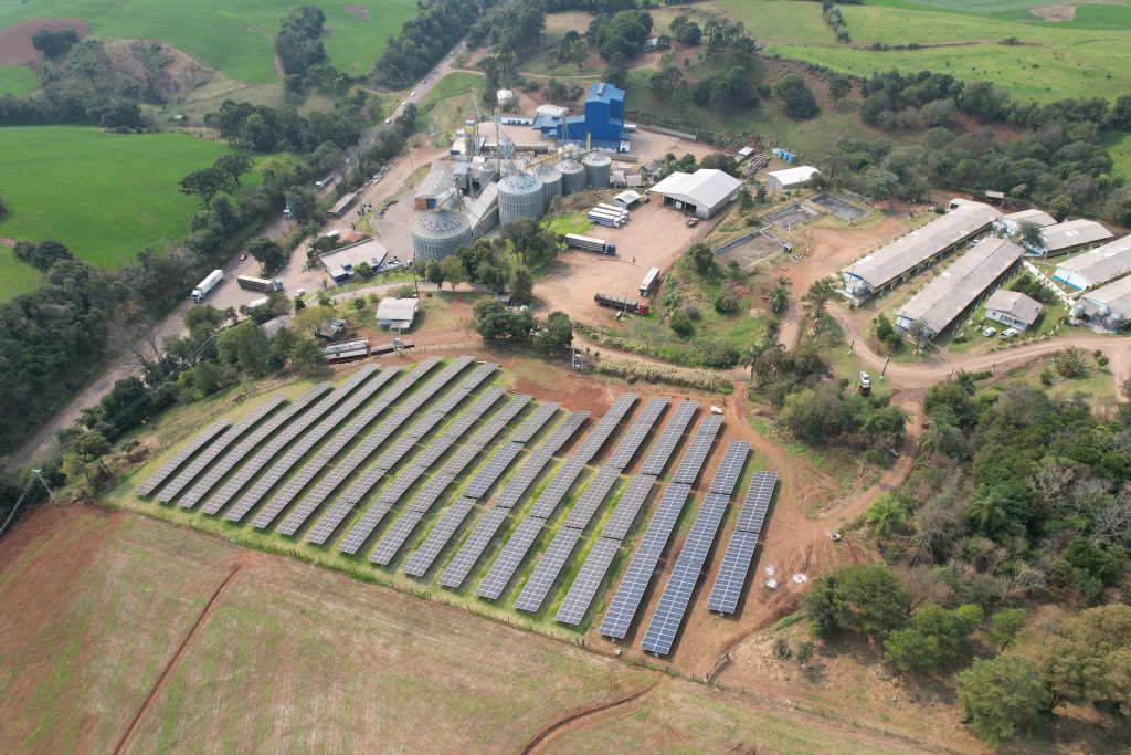 Energia solar rural: Vista aérea de propriedade rural com usina de energia solar abastecendo agroindústria e produção agrícola.
