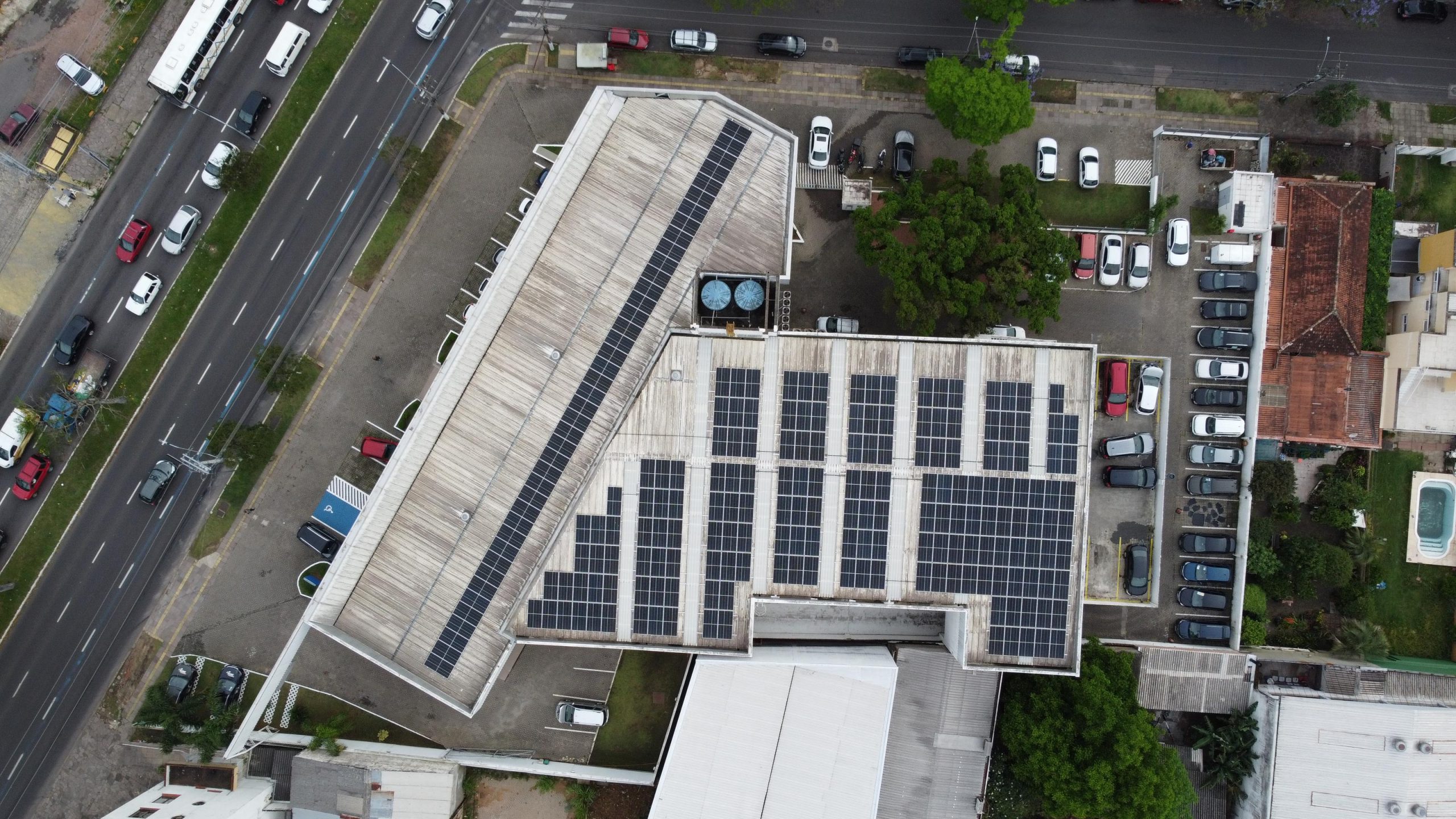 Vista aérea de edifício comercial com painéis solares fotovoltaicos instalados no telhado.